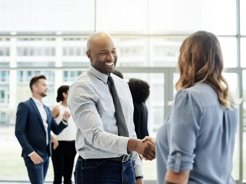 Une poignée de main souriante entre un recruteur et une candidate